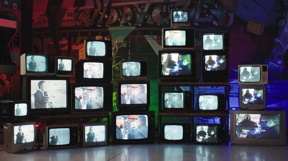 Many analogue television sets along a wall